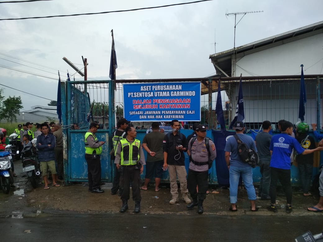 Die Polizei überwacht die Lage während die Arbeiter*innen das Fabrikgelände PT Sentosa Utama Garmindos besetzen © LIPS