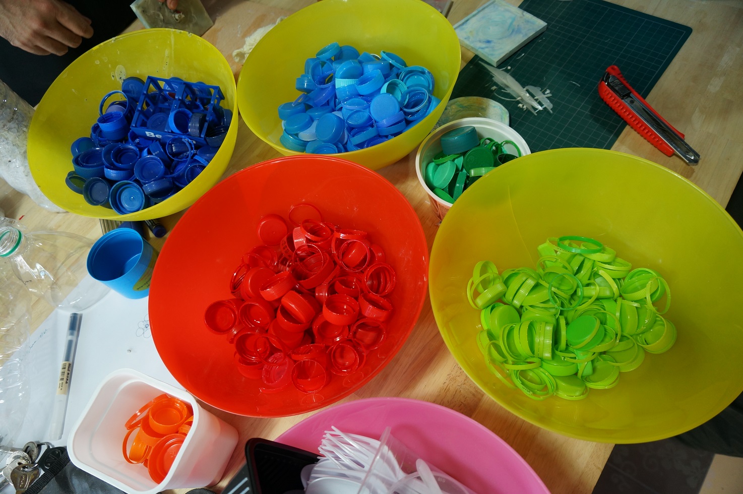 Yolo Plastikmüll Workshop: Bunte Flaschendeckel aus Plastik werden nach Farben sortiert, um sie zu recyceln © Sirinya Wattana