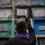 Ein Pfarrer betrachtet Urnengräber